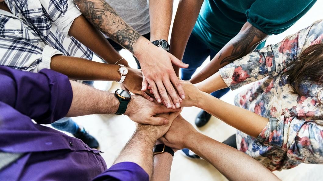 Handen op elkaar voor teamwork