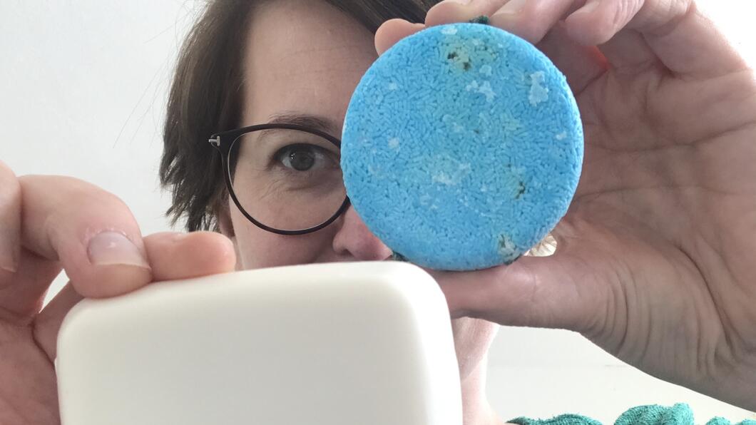 Eveline houdt een zeepbar en shampoobar omhoog voor de camera