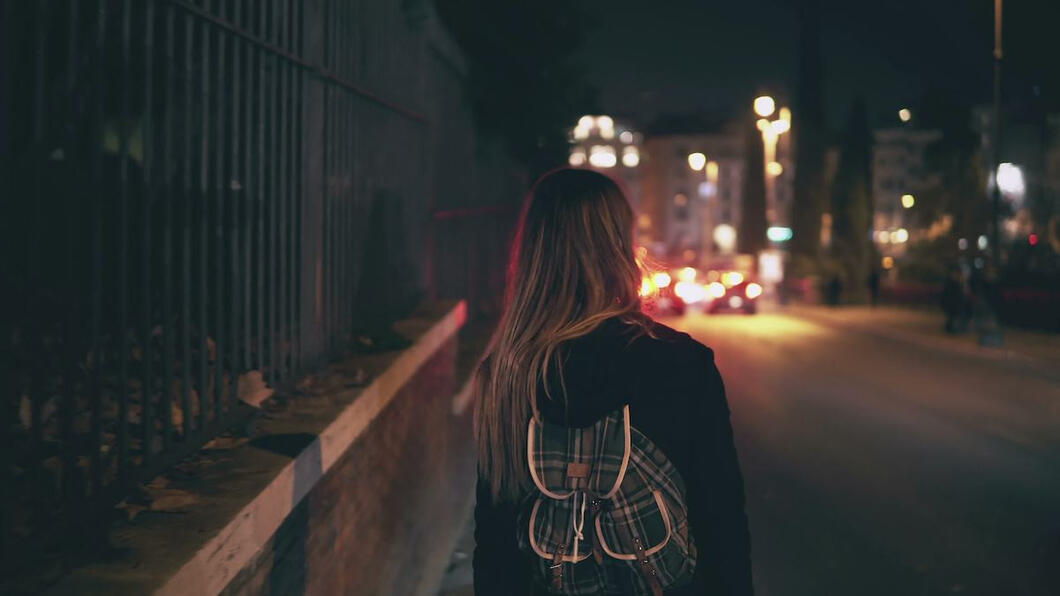Vrouw alleen op straat in de avond