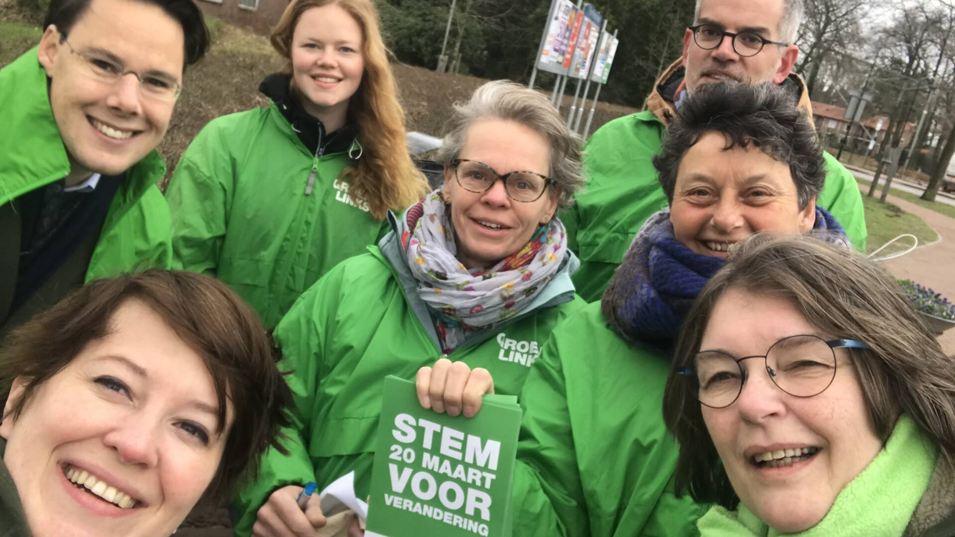 Groepsselfie met groene jasjes en folders met Stem GroenLinks