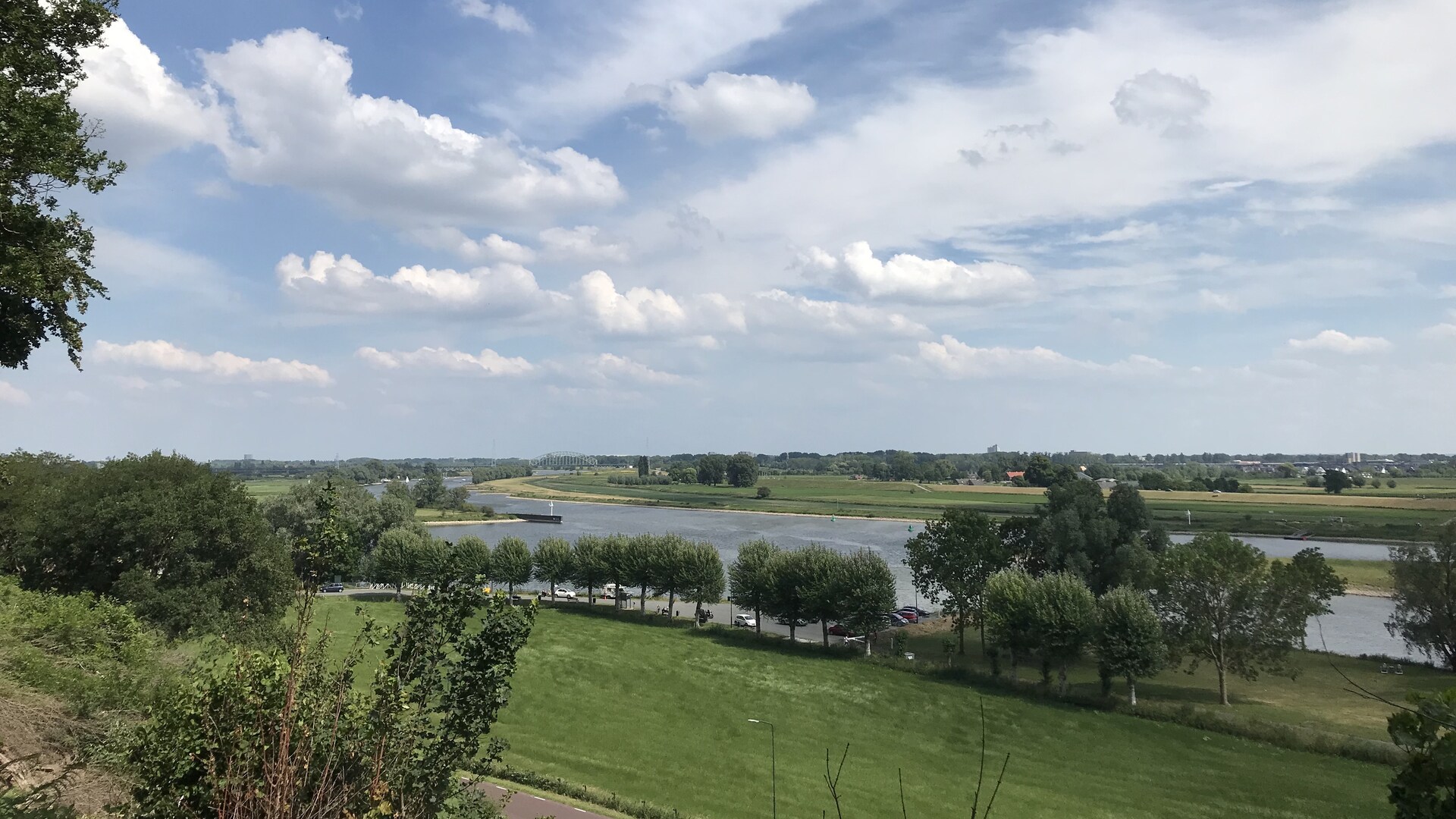 Weids uitzicht over de uiterwaarden en Rijn, met Hollandse wolkenlucht